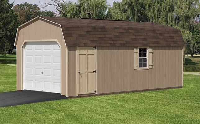 A brown mini-barn with a white garage door sits in a yard.