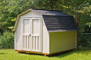 A shed with a gambrel-style roof in the backyard